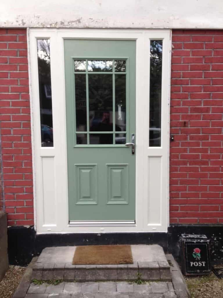 Green front door with red brick wall