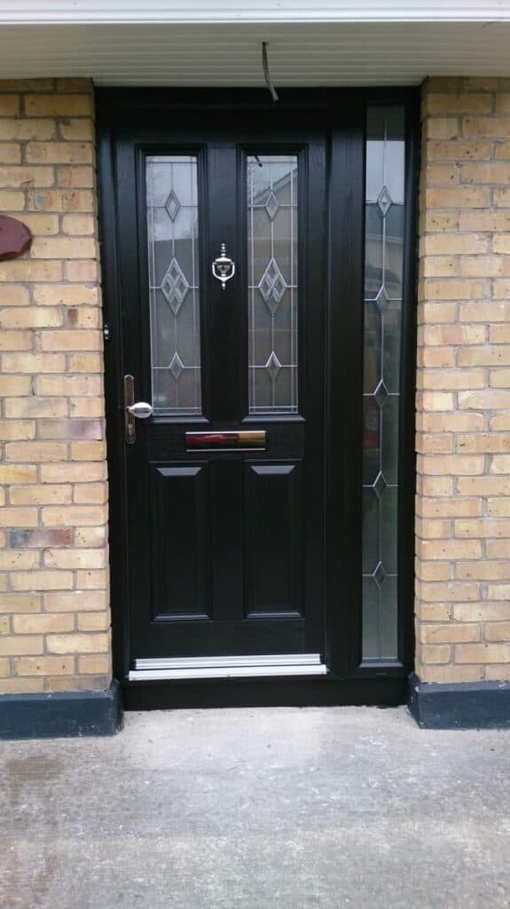 Black front door with glass panels and knocker.