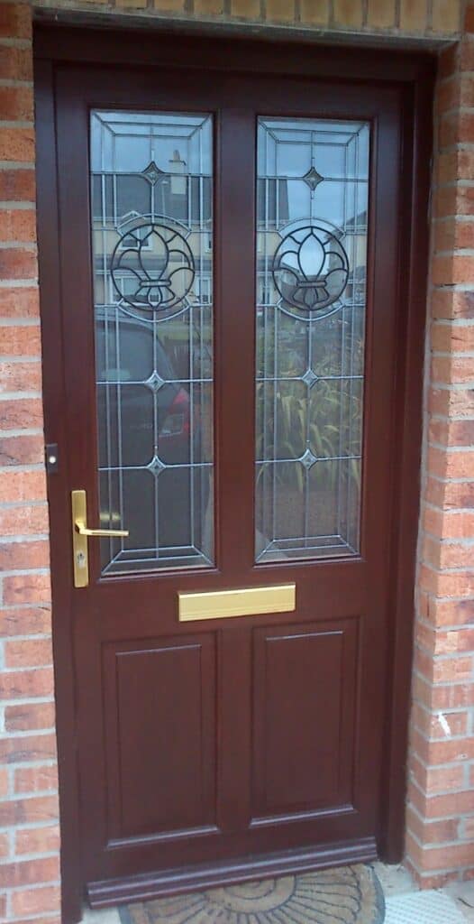 Wooden front door with stained glass panels.