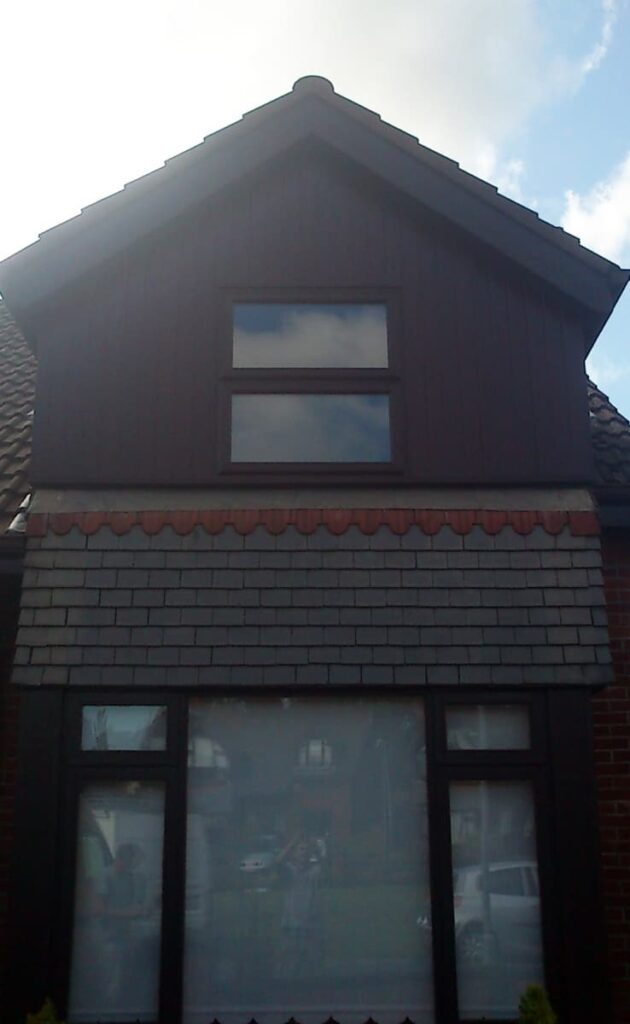 Gabled roof house with brick and tiled facade.