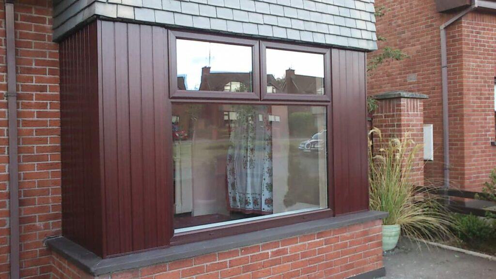 Modern brown bay window on brick house