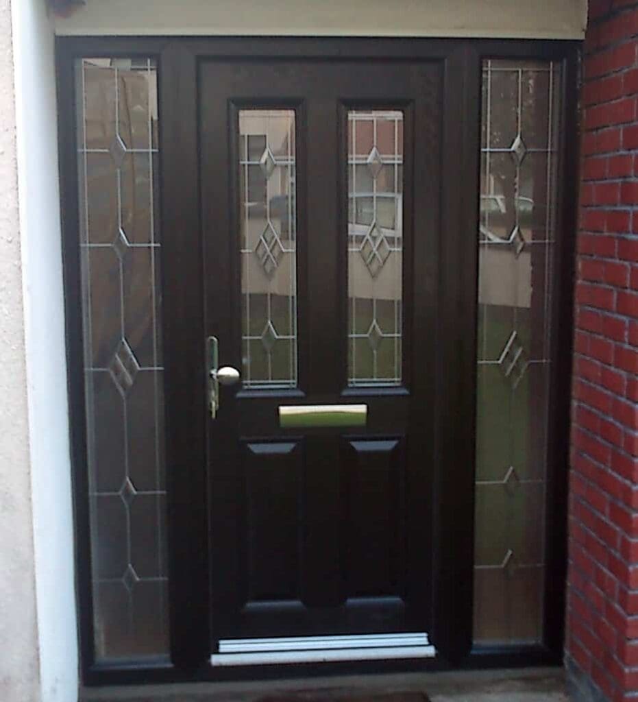 Black front door with glass panels and brick wall