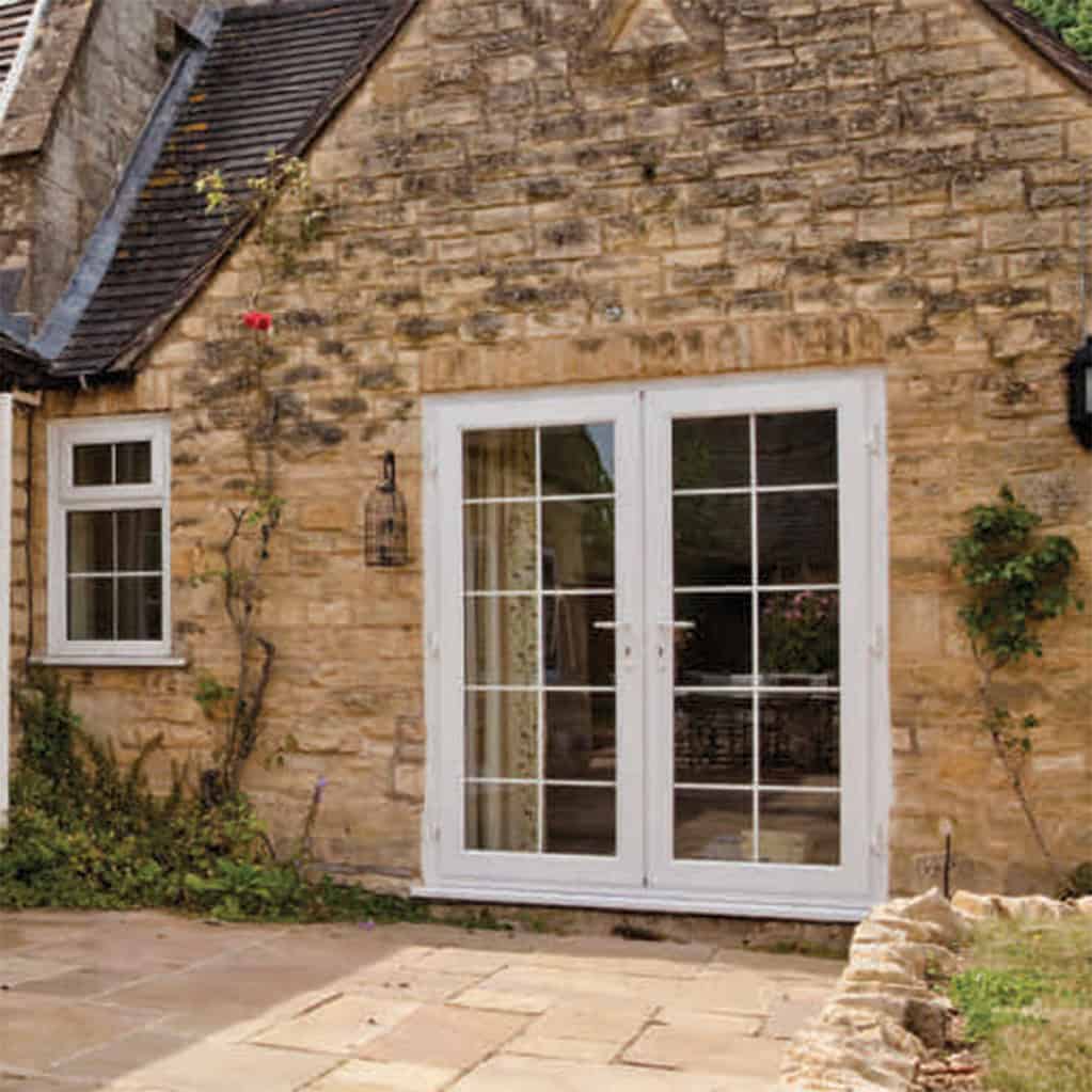 Cottage with stone walls and white double doors