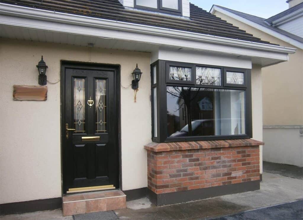 House entrance with black door and bay window.